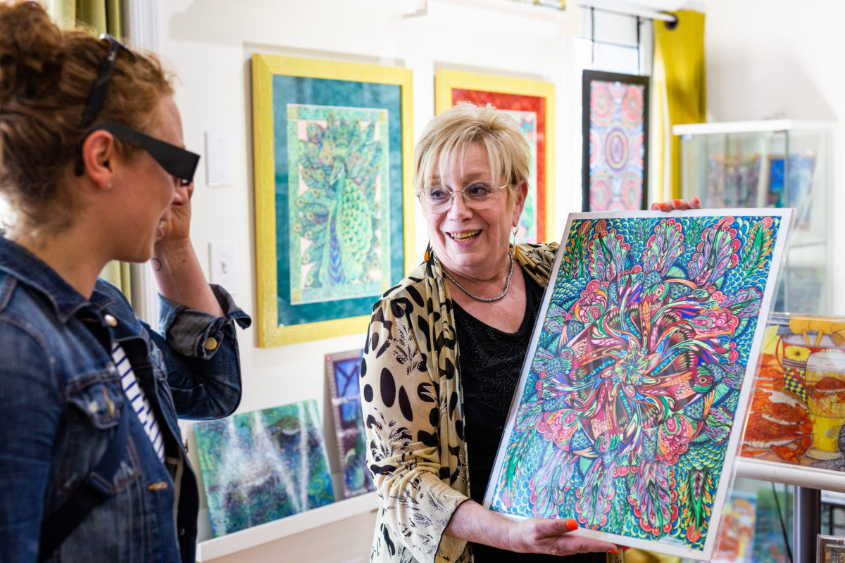 Artist Debbie Lynn Zwiebach shows off a painting