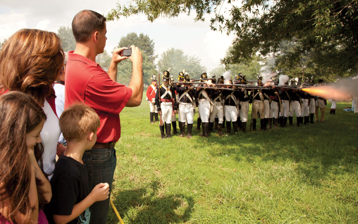 Person taking a photograph of marchers at Fort McHenry.