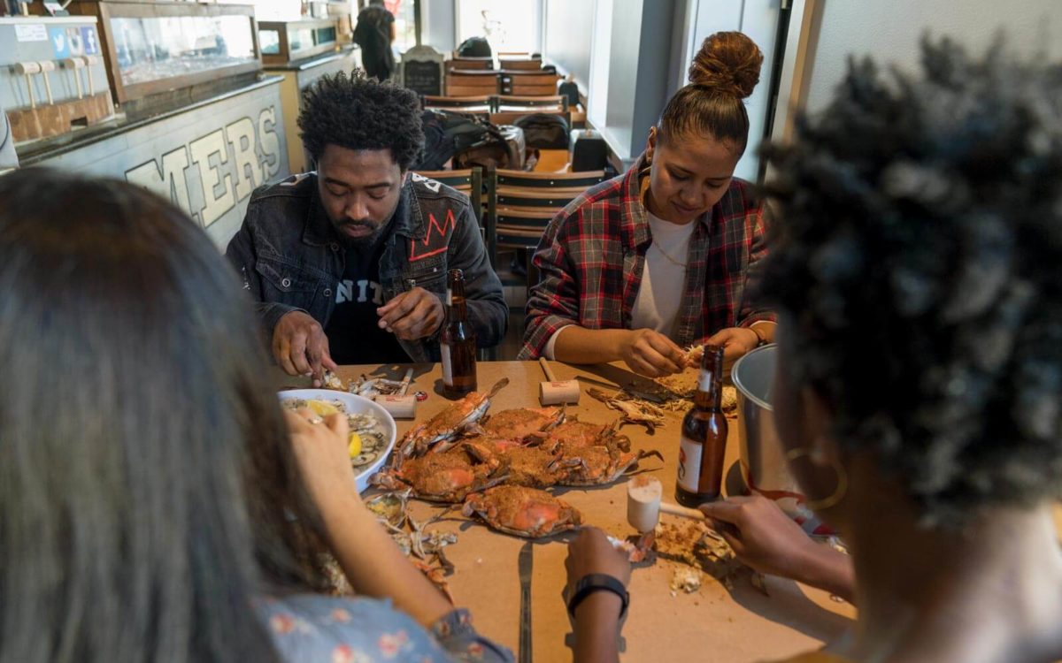 Four customers eating blue crabs at locust point streamers in Baltimore.