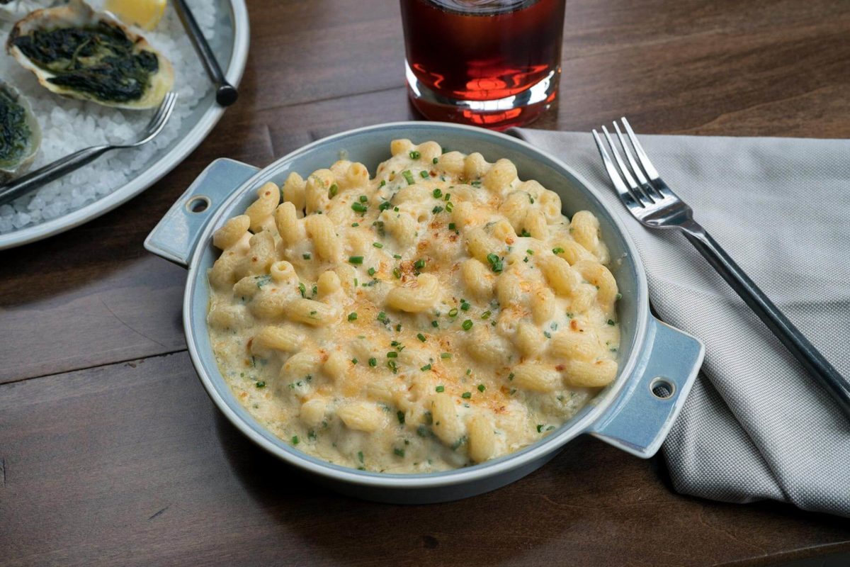 Plated crab mac and cheese with beverage at True Chesapeake in Baltimore.