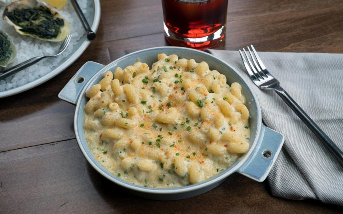 Plated crab mac and cheese with beverage at True Chesapeake in Baltimore.