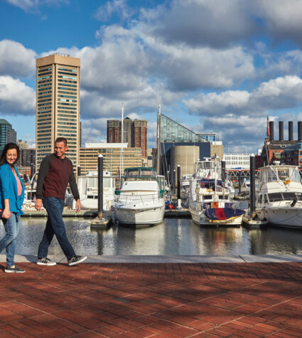 Family walking along the water in the Inner Harbor.