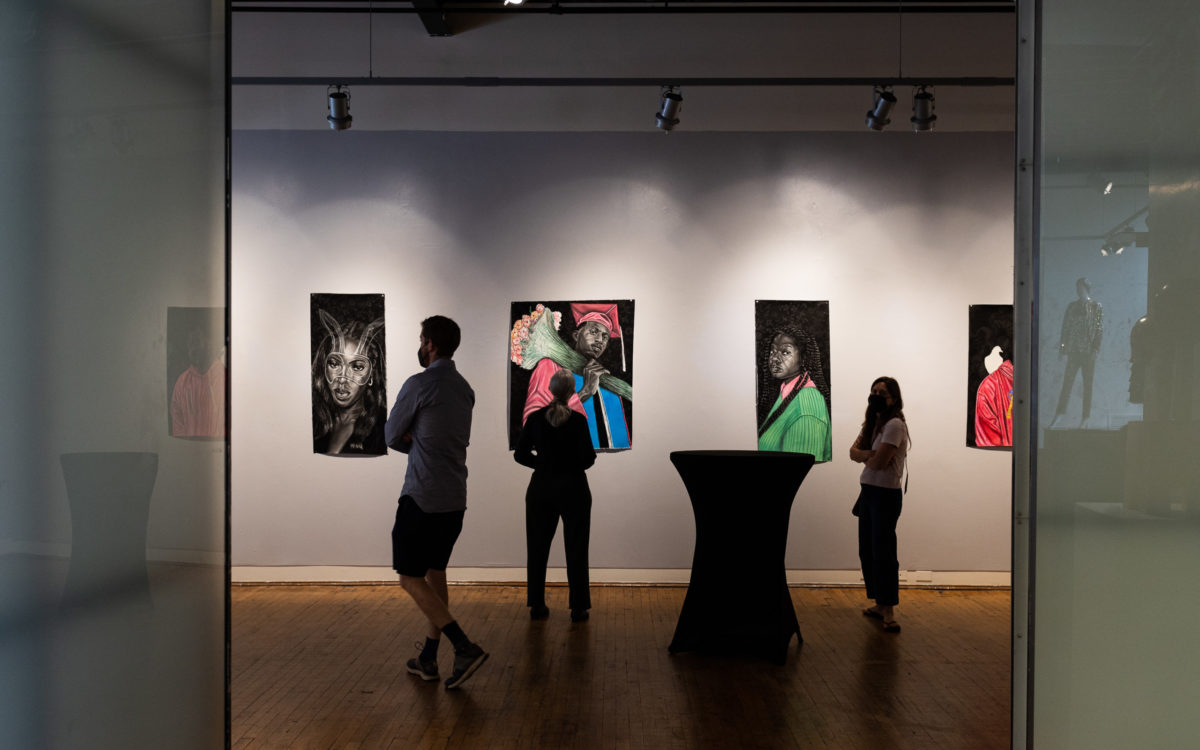 A crowd looks at sketches of African Americans in the gallery space at the Eubie Blake Cultural Center.