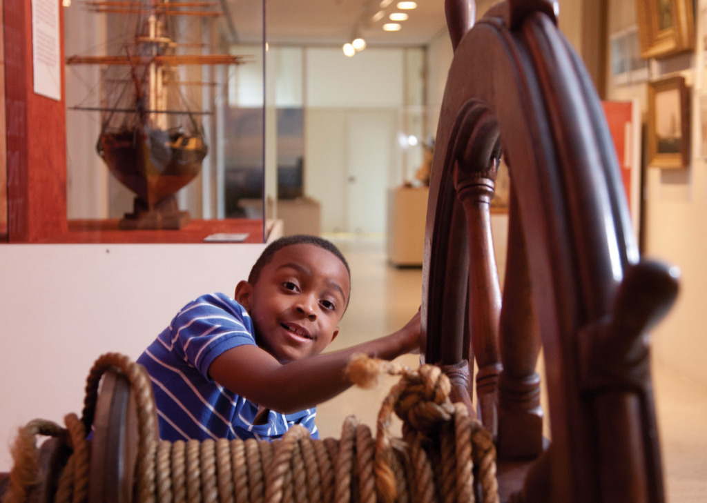 Ken Stanek Photography Boy playing with a ships wheel at the Maryland Historical Society