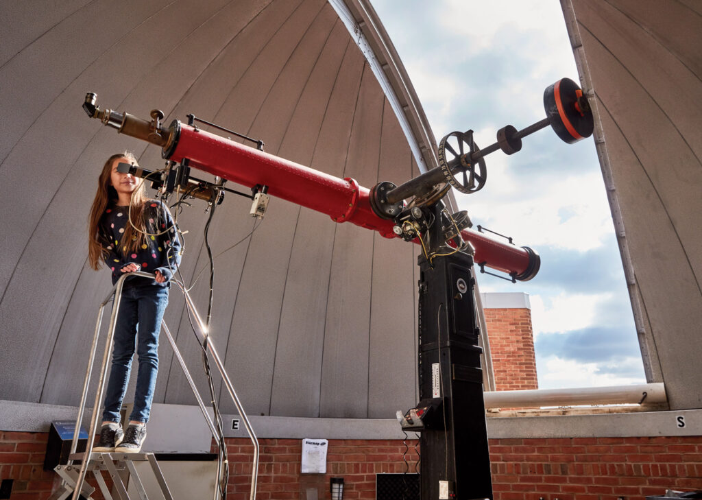 Child looking through a telescope at The Baltimore Science Center.