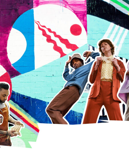 Cut outs of local artists and creators in front of a Baltimore mural wall