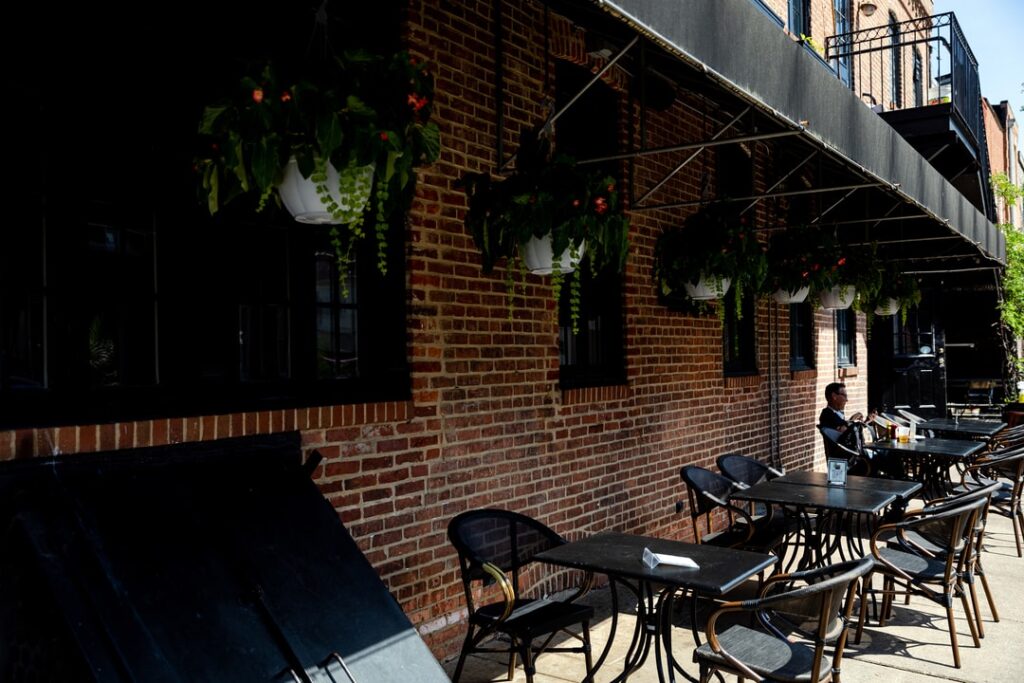 shot of outdoor chairs and tables against a brick wall