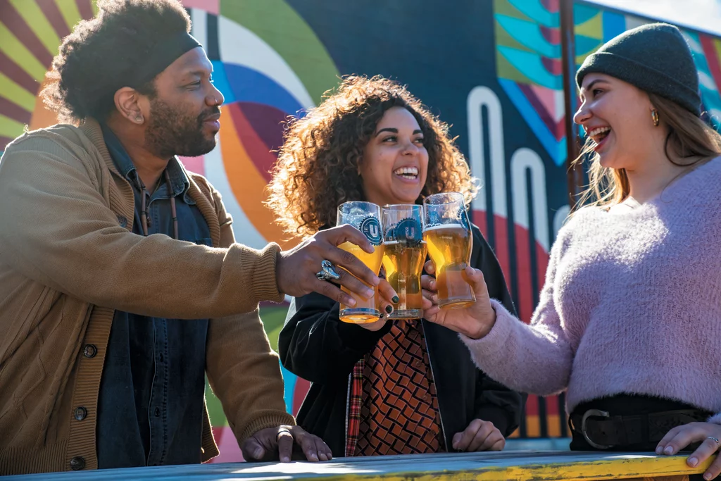 Three people enjoying beers outside