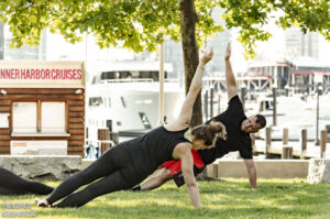 a man and a woman do yoga by the water